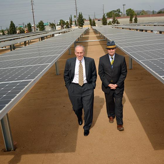 two men walking through solar panels