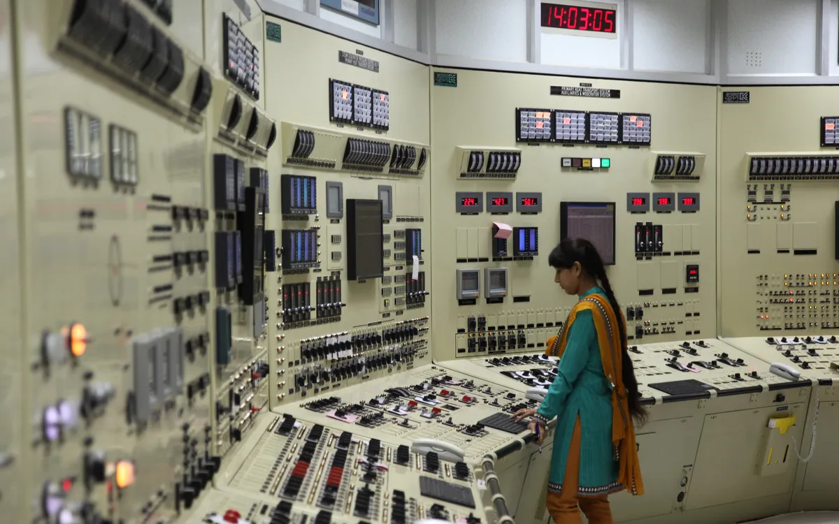 indian woman standing in the control room of a nuclear power plant