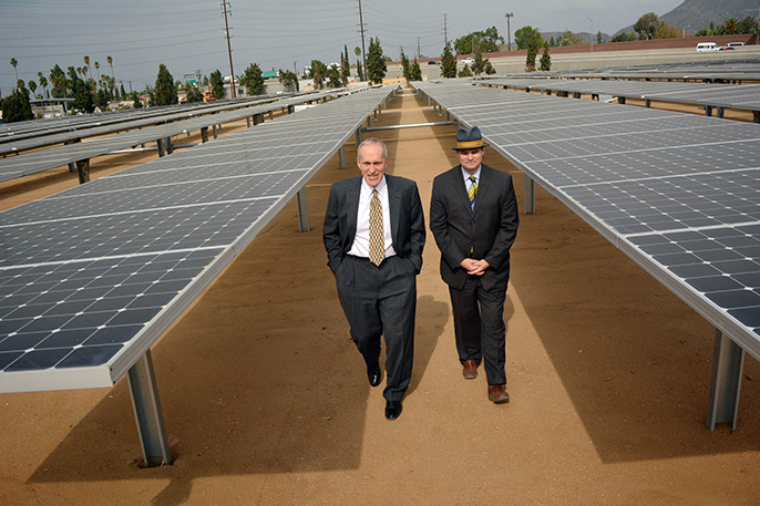 two men walking through solar panels