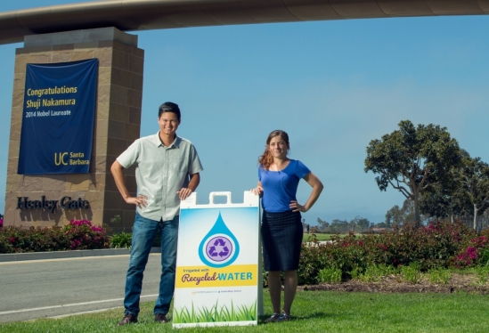 two people posing with a signboard